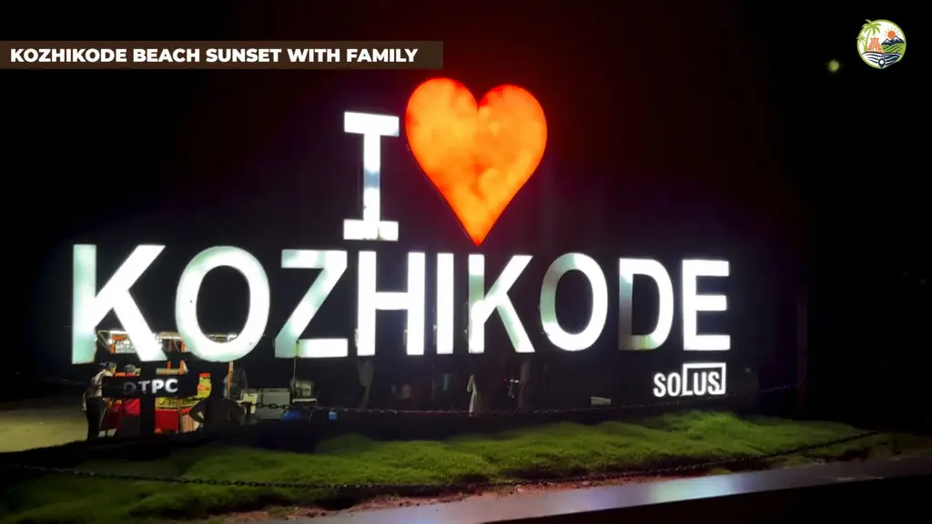 Family walking along the Kozhikode Beach promenade at sunset